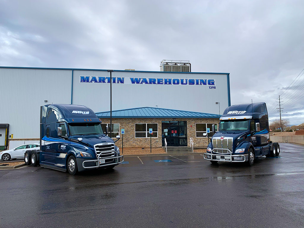 Martin warehouse transport services warehousing building with two semi trucks parked,