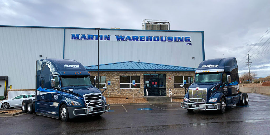 Martin warehouse transport services warehousing building with two semi trucks parked.